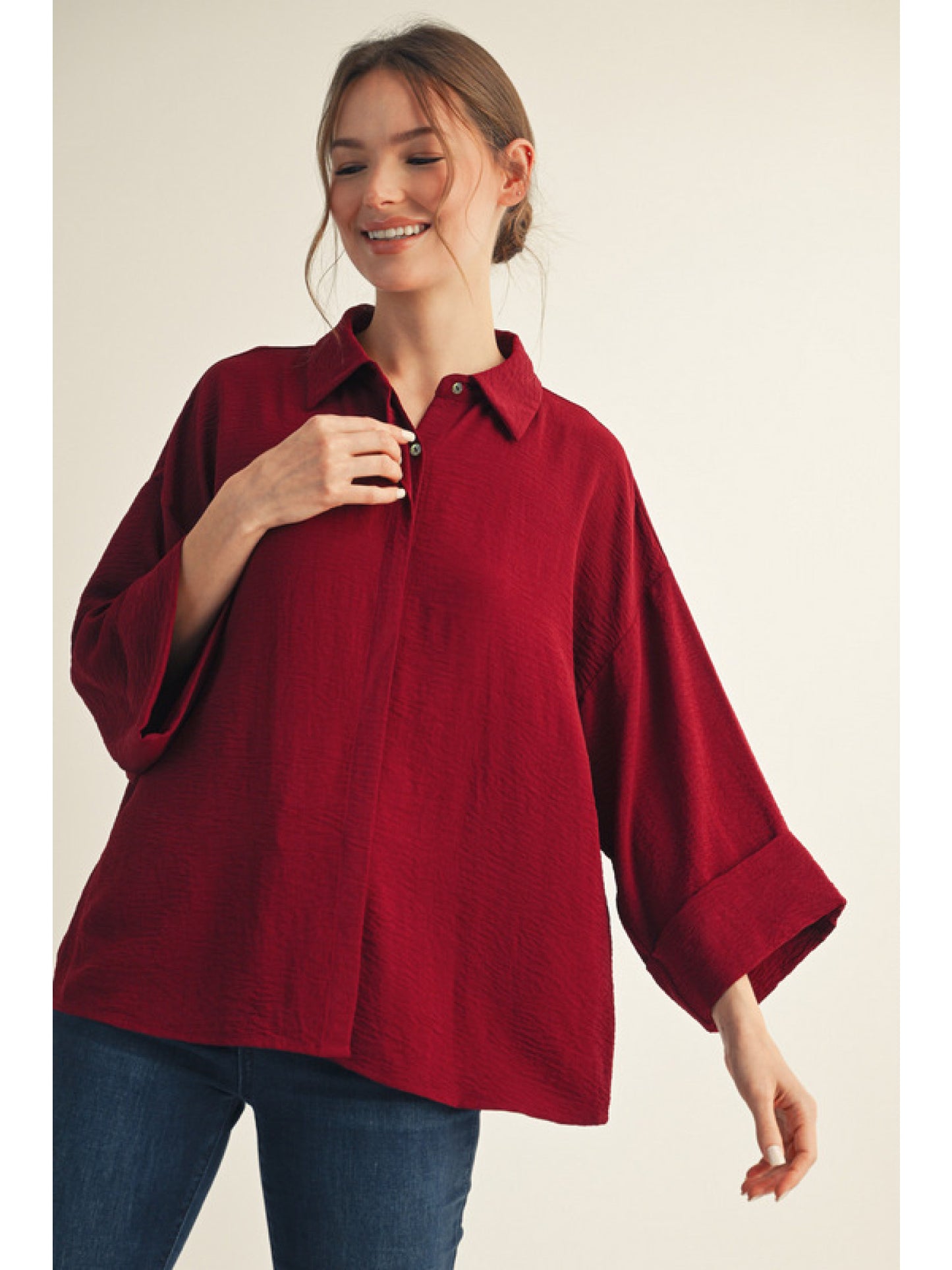 Burgundy 3/4 sleeves button down top, textured solid fabric, folded cuff detail, hided button, collared neckline.