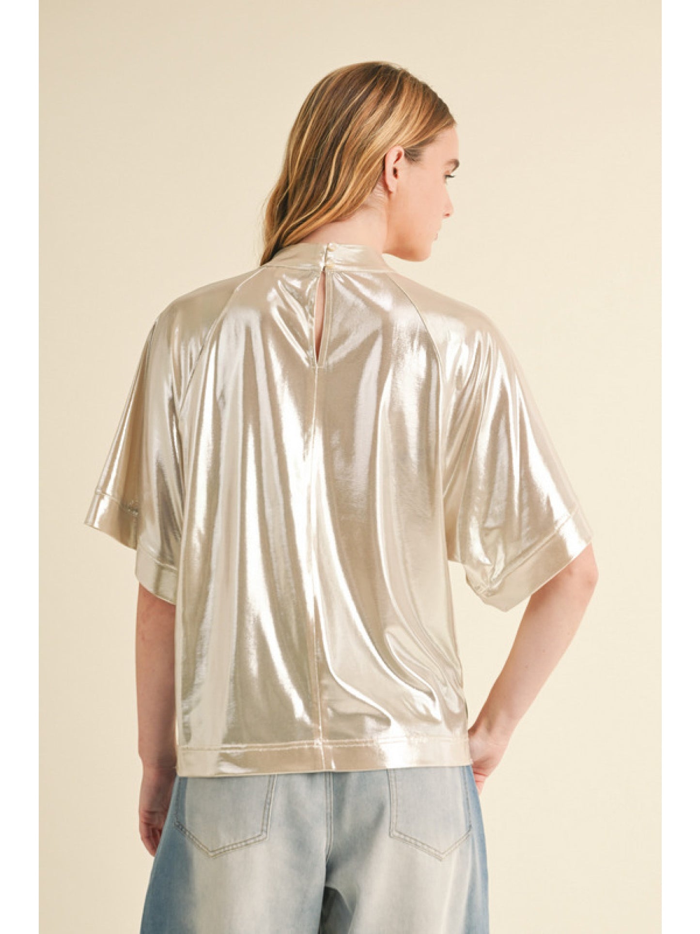 Champagne Glossy fabric top with mock neck, back key hole, half wide sleeves, and vented hemline.